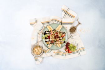 Fruit with chocolate sauce and nuts on plate