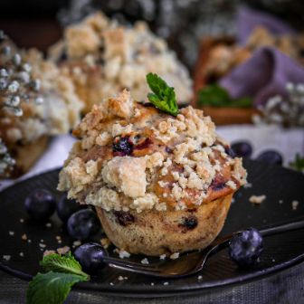 Blaubeermuffin mit Streusel auf Teller dekoriert