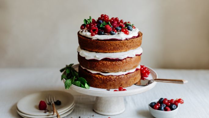 Naked Cake mit Creme und Beeren auf Tortenteller