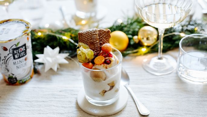 Tiramisu auf weihnachtlich gedecktem Tisch mit Mandel-Joghurtalternative Natur