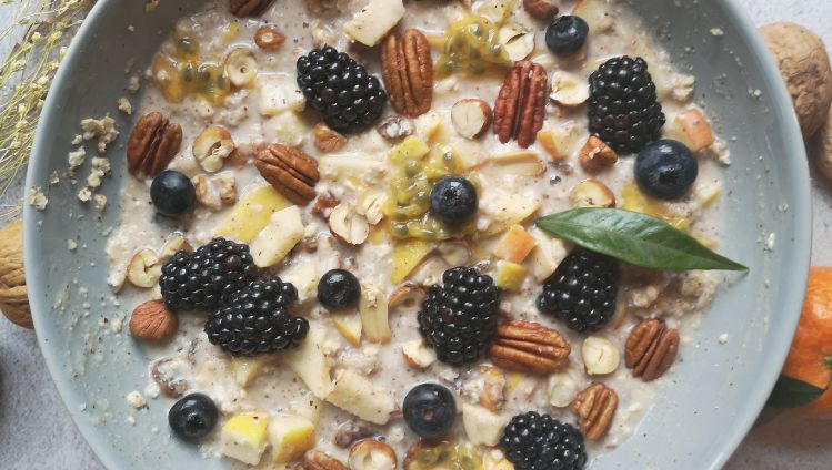 Birchermüsli mit Früchten und Nüssen garniert und Nektarinen und Nüssen rundherum dekoriert