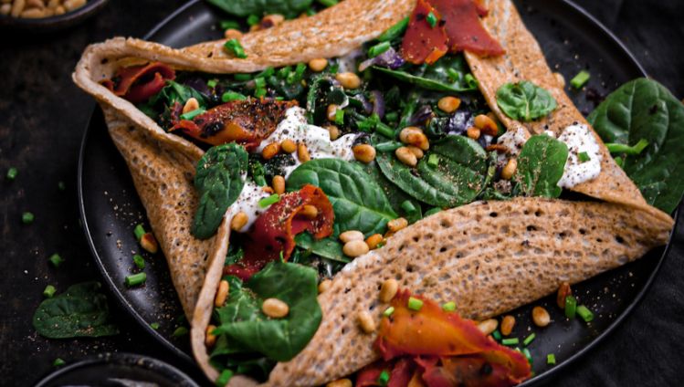 Buchweizencrepe mit Spinat und Karottenlachs gefüllt und seitlich eingeklappt und rundherum dekoriert