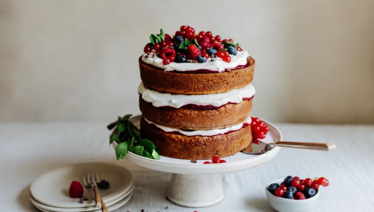 Naked Cake mit Creme und Beeren auf Tortenteller