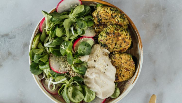 Spinat Falafel mit Feldsalat, Radieschen und Creme in Schüssel dekoriert