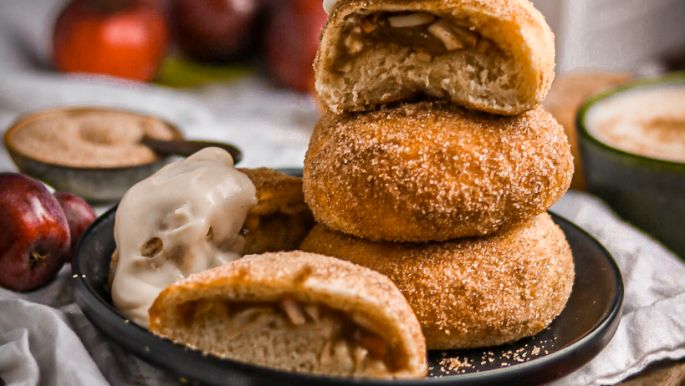 Apfel-Zimt-Buns auf Teller mit Äpfeln rundherum dekoriert