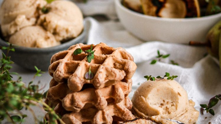 Waffeln mit Birnen-Bananen-Eis und im Hintergrund dekoriert mit Birnen, Eis und Kaffee