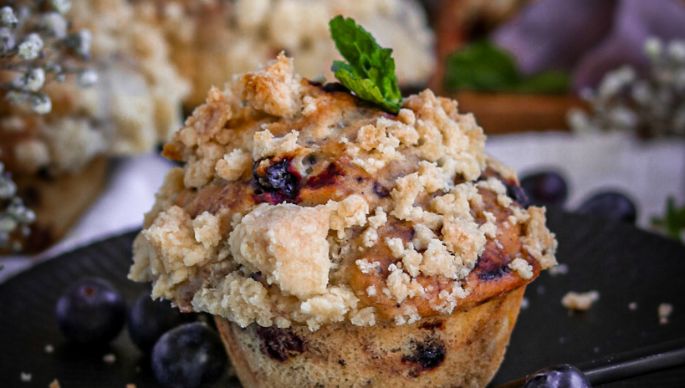 Blaubeermuffin mit Streusel auf Teller dekoriert