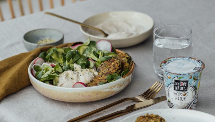 Spinat Falafel mit Feldsalat, Radieschen und Creme in Schüssel auf Tisch gedeckt